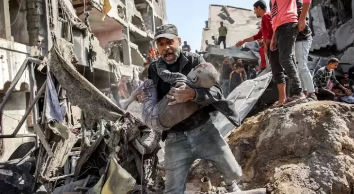 فلسطيني يحمل طفله المصاب عقب قصف إسرائيلي شمال قطاع غزة.webp