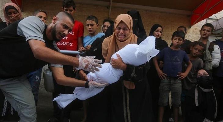 فلسطينية تشيع طفلها الذي استشهد بمجزرة في غزة.jpg