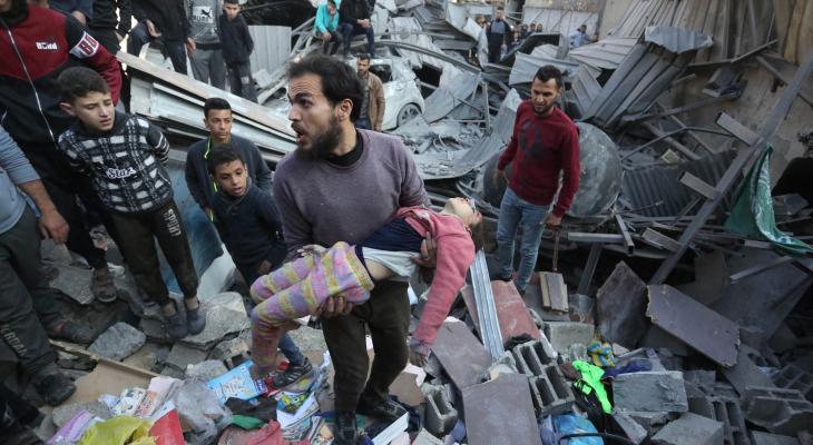مواطن يحمل طفلته عقب مجزرة إسرائيلية في غزة