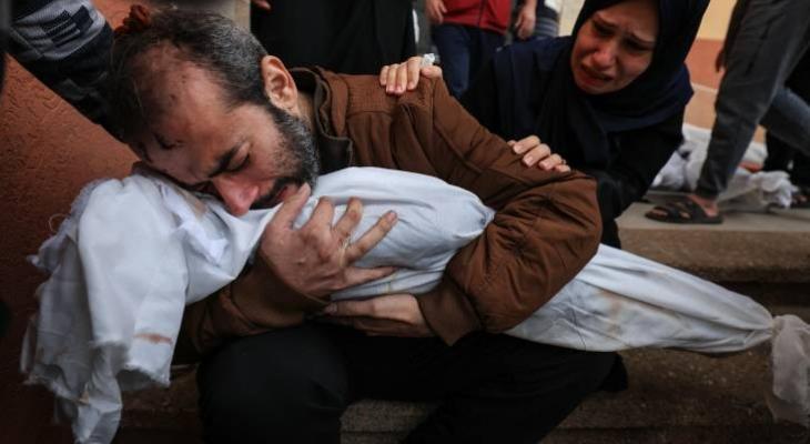 فلسطيني يودع طفلته التي استشهدت بمجزرة إسرائيلية في غزة.jpg