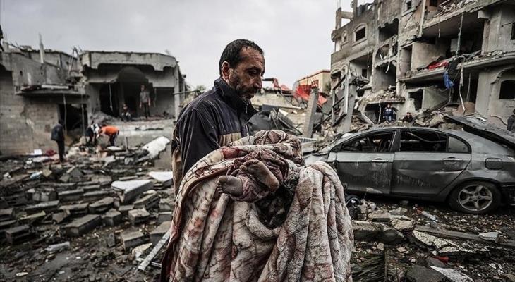 فلسطيني يحمل طفلته بعد استشهادها في مجزرة إسرائيلية بغزة.jpg