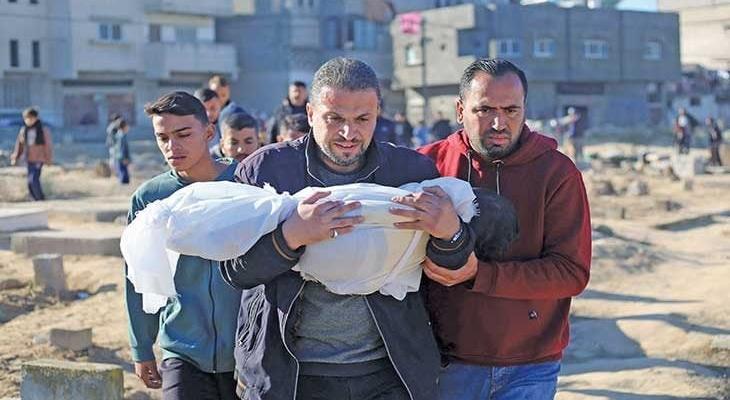 فلسطيني يحمل طفله عقب استشهاده بمجزرة إسرائيلية.jpg