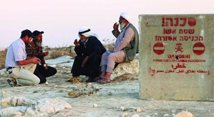 فلسطينيون أمام لوحة في مسافر يطا.jpeg