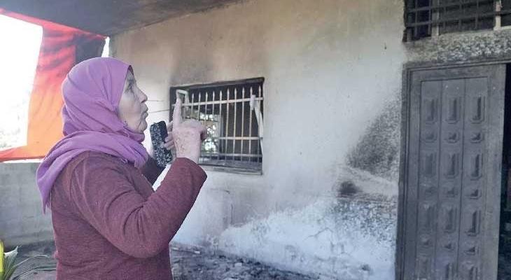 سيدة أمام منزلها بعد اعتداء للمستوطنين.jpg