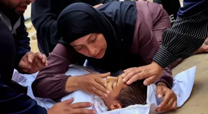 سيدة فلسطينية في غزة تودعها طفلها الشهيد.webp