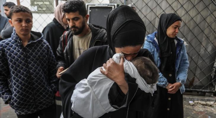 سيدة تحتضن طفلها الشهيد.jpg