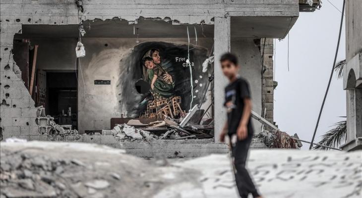 طفل أمام لوحة فنية في منزل مدمر بغزة.jpg