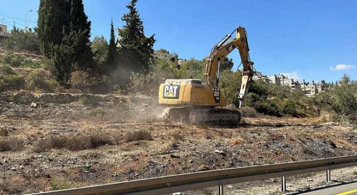 جرافة إسرائيلية تقوم بعمليات تجريف في أراض فلسطينية.jpg