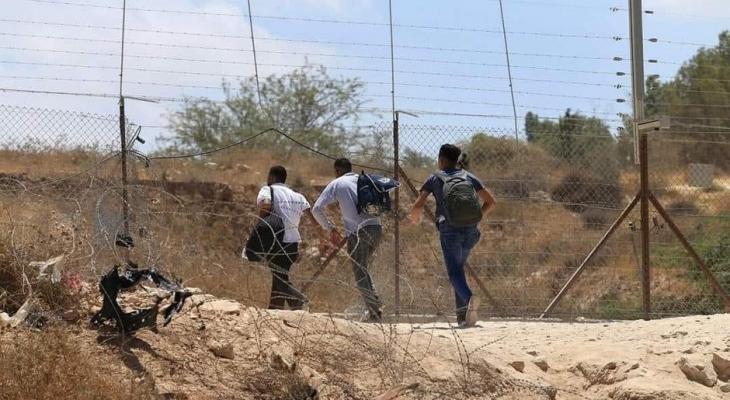 عمال فلسطينيون يجتازون جدار الفصل في الضفة الغربية.jpg