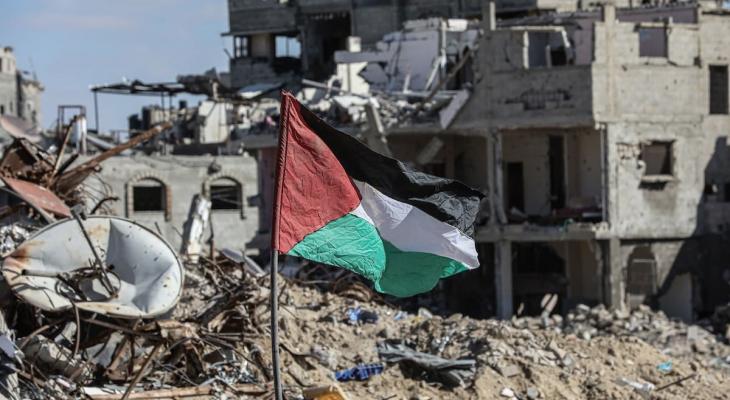 رفع علم فلسطين قرب منازل مدمرة في غزة.jpg
