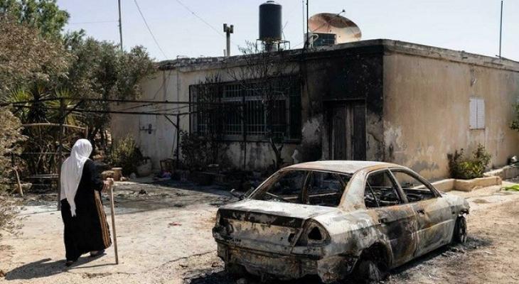 مسنة فلسطينية بجانب مركبة مدنية محترقة إثر اعتداءات المستوطنين.jpg