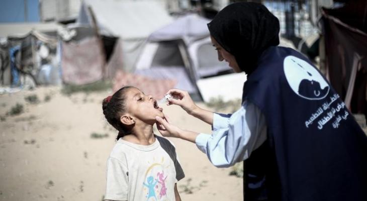 موظفة أممية تقوم بـ تطعيم طفلة في غزة.jpg