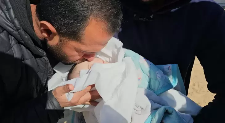 فلسطيني يودع طفله الرضيع في غزة.webp
