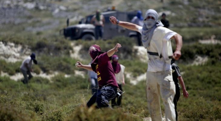 مستوطنون يلقون الحجارة على فلسطينيين.jpeg