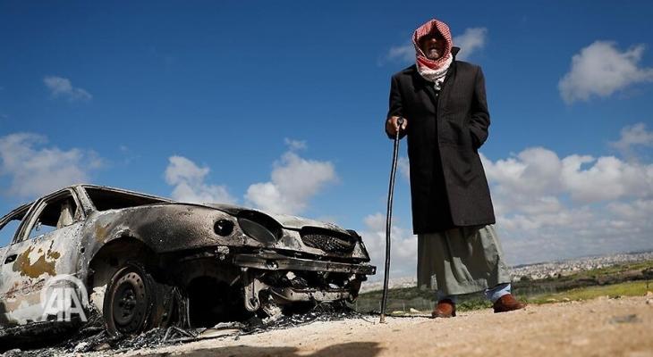 مسن فلسطيني بجانب مركبة أحرقها المستوطنون.jpg