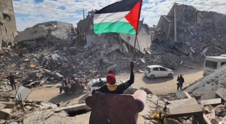 شاب فلسطيني يرفع علم فلسطين وسط الدمار في غزة