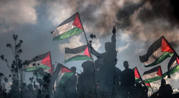فلسطينيون يرفعون علم فلسطين في غزة مع شارة النصر.jpg