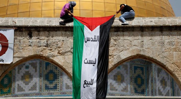 شبان يعلقون عليم فلسطين قبالة قبة الصخرة.jpg