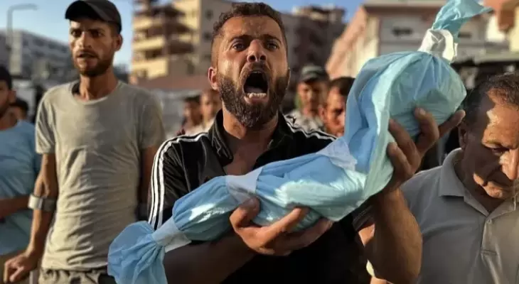مواطن يحمل جنين قتله الاحتلال في غزة.webp