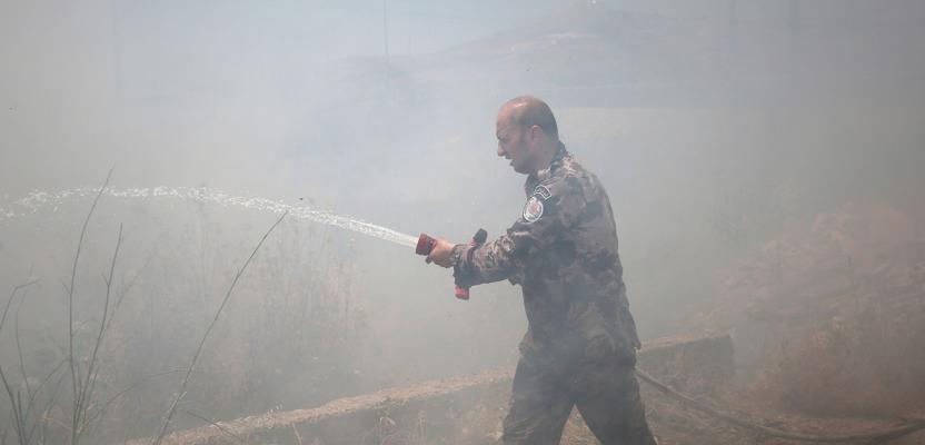 رجال الإطفاء وفلسطينيون يعملون على إخماد حرائق اندلعت في أراضٍ زراعية قرب بلدة حوارة جنوب نابلس