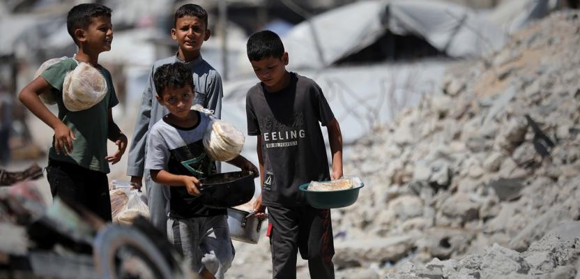 أطفال نازحون يتجمعون للحصول على وجبات طعام بمدينة غزة