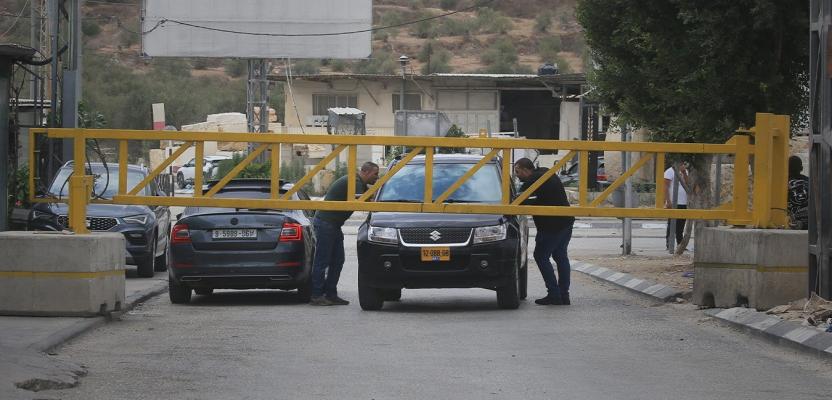 فلسطينيون يشقون طريقهم عبر بوابة حديدية غرب نابلس في ظل استمرار القيود الإسرائيلية على الحركة لليوم الثاني خلال عطلة 