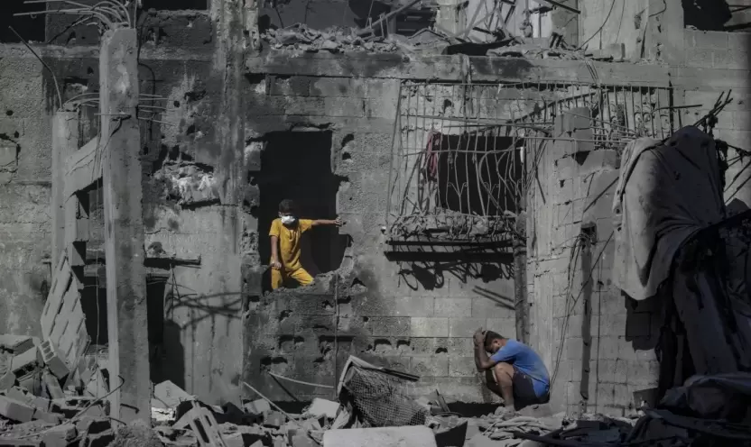 فلسطينيون وسط أنقاض مبان مدمرة