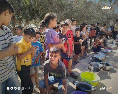 مواطنون يتجمعون للحصول على الطعام من تكية خيرية في دير البلح وسط قطاع غزة.10.jpg