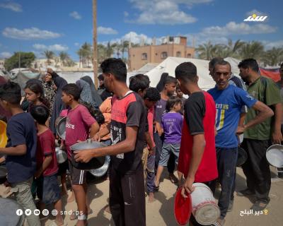 مواطنون يتجمعون للحصول على الطعام من تكية خيرية في دير البلح وسط قطاع غزة.1.jpg