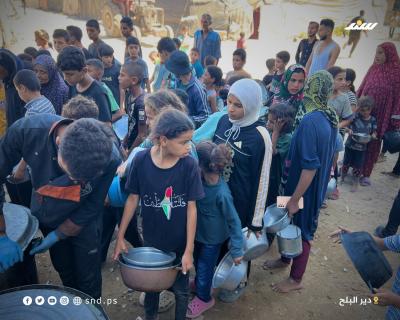 مواطنون يتجمعون للحصول على الطعام من تكية خيرية في دير البلح وسط قطاع غزة.8.jpg