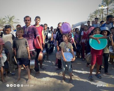 مواطنون يتجمعون للحصول على الطعام من تكية خيرية في دير البلح وسط قطاع غزة.6.jpg
