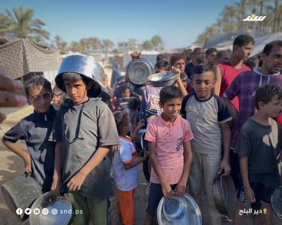مواطنون يتجمعون للحصول على الطعام من تكية خيرية في دير البلح وسط قطاع غزة.5.jpg