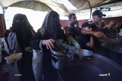 أطفال ونساء يصطفون للحصول على وجبات غذائية مجانية من إحدى التكيات في مخيم النصيرات وسط قطاع غزة1.jpg