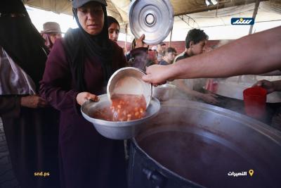 أطفال ونساء يصطفون للحصول على وجبات غذائية مجانية من إحدى التكيات في مخيم النصيرات وسط قطاع غزة4.jpg