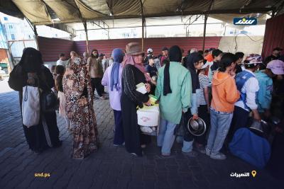 أطفال ونساء يصطفون للحصول على وجبات غذائية مجانية من إحدى التكيات في مخيم النصيرات وسط قطاع غزة6.jpg