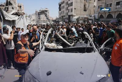 فلسطينيون وعناصر من الدفاع المدني يتجمعون حول مركبة مدمرة في مدينة غزة بعد استهدافها بغارة إسرائيلية4.jpg