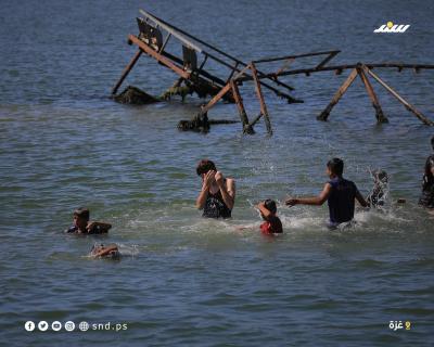 أطفال يقضون أوقاتاً على شاطئ بحر مدينة غزة خلال يوم حار5.jpg