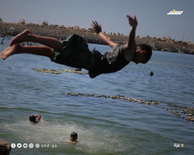 أطفال يقضون أوقاتاً على شاطئ بحر مدينة غزة خلال يوم حار3.jpg