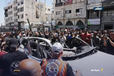 فلسطينيون وعناصر من الدفاع المدني يتجمعون حول مركبة مدمرة في مدينة غزة بعد استهدافها بغارة إسرائيلية3.jpg