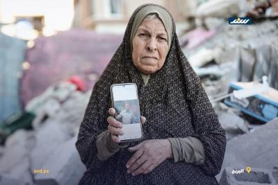 المسنة أم عطا تفتش بين أنقاض منزلها بمخيم البريج بحثاً عن رفات أبنائها الأربعة3.jpg