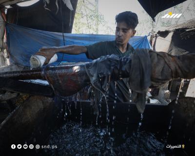 عمال فلسطينيون ينتجون الوقود من النفايات البلاستيكية في مخيم النصيرات وسط قطاع غزة4.jpg