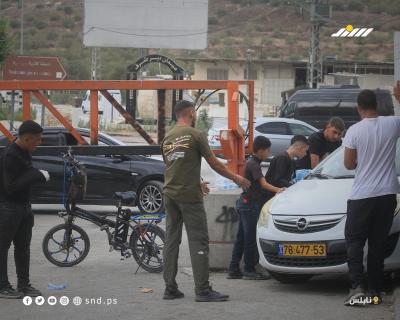 فلسطينيون يشقون طريقهم عبر بوابة حديدية غرب نابلس في ظل استمرار القيود الإسرائيلية على الحركة لليوم الثاني خلال عطلة «عيد العرش اليهودي.jpg