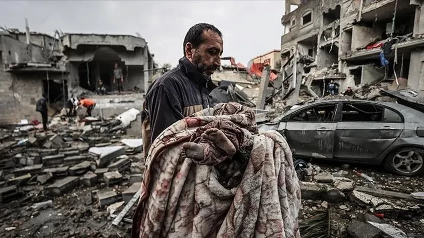 فلسطيني ينقل جثمان طفل بعد مجزرة إسرائيلية في غزة.webp