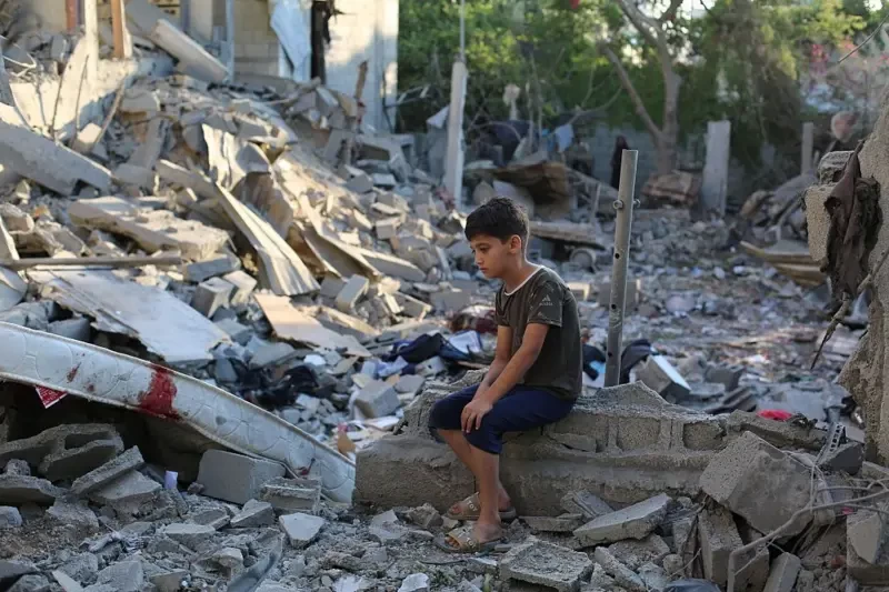 طفل فلسطيني يجلس على ركام منزل عائلته في غزة.webp